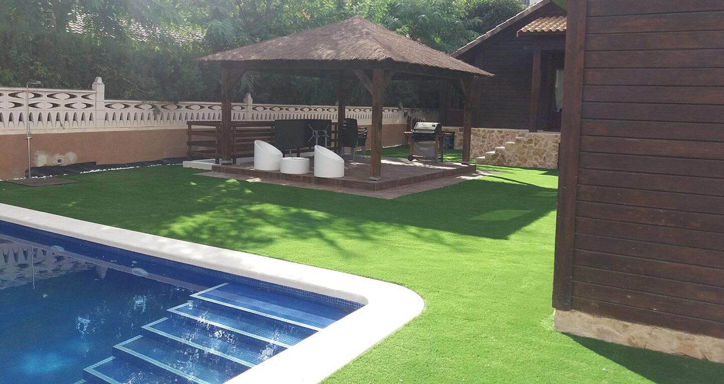 Instalación de césped artificial Calpe de alta calidad en jardín residencial con piscina